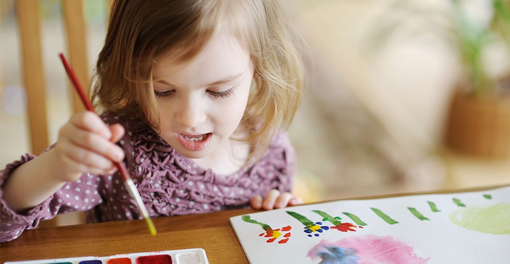 A young child exploring color through painting